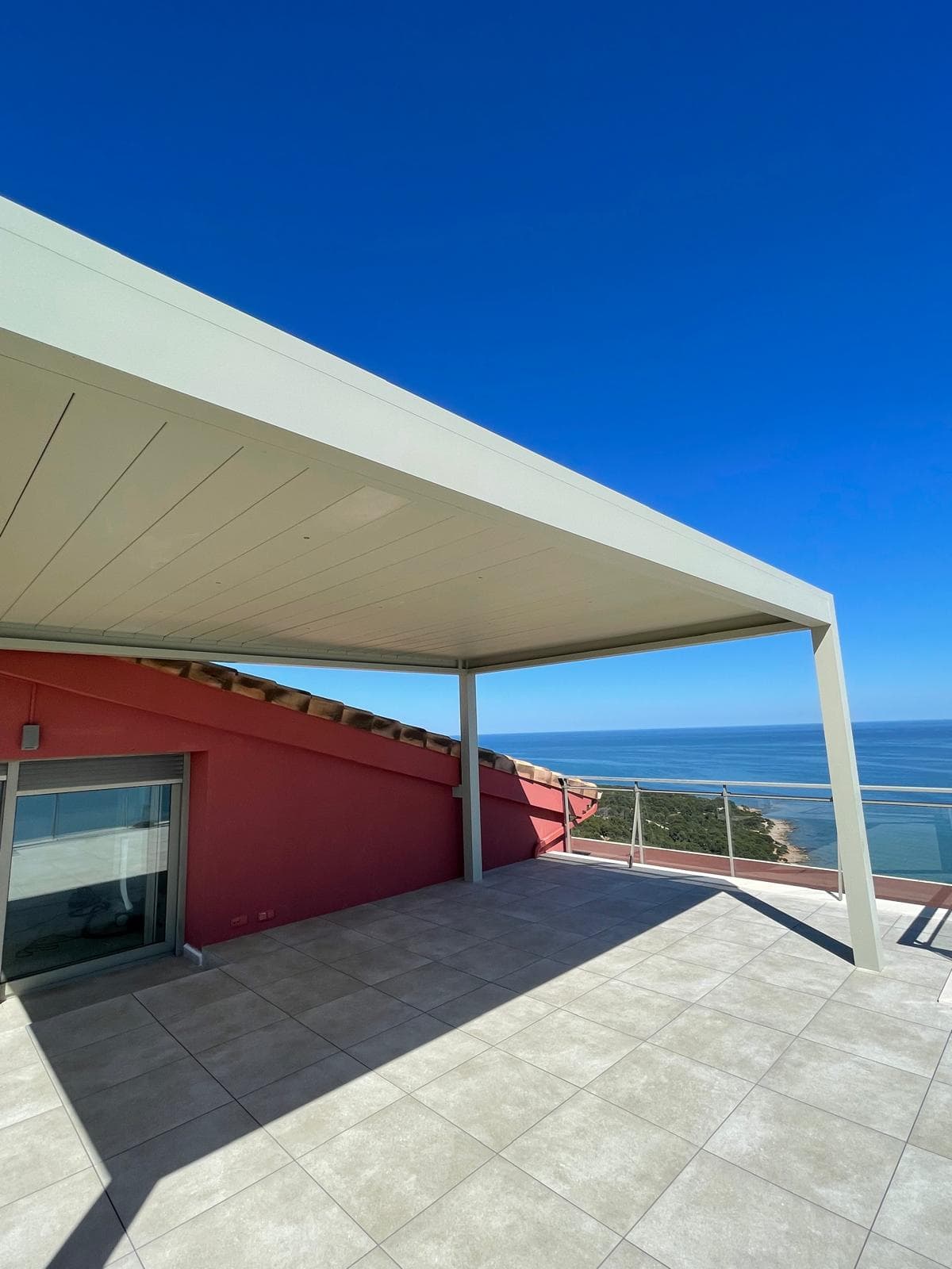 Pérgola bioclimática blanca con vistas al mar, diseño moderno premium