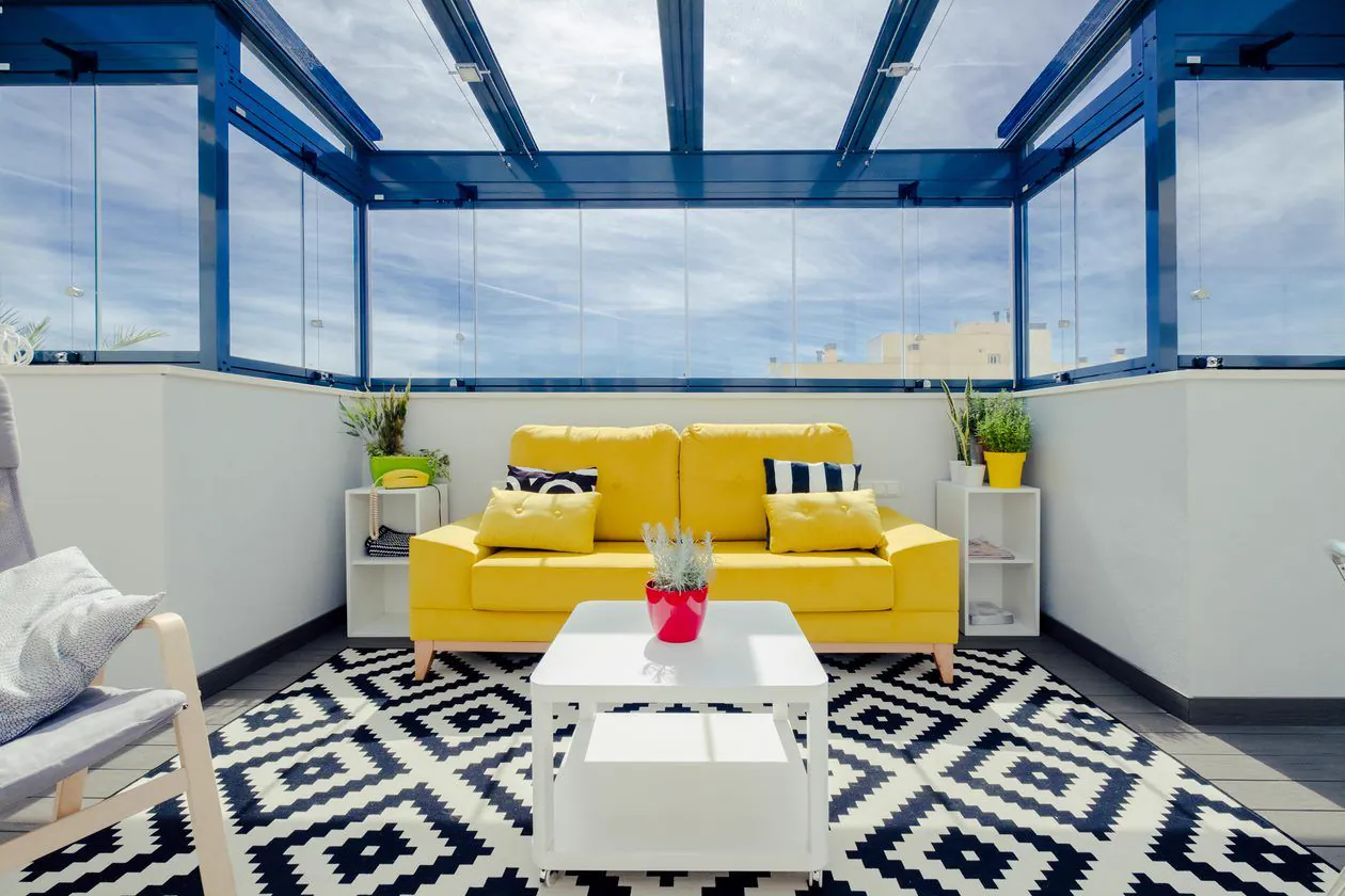 Cerramiento de terraza con cristal y perfilería de aluminio. Ejemplo de solución para proteger del viento y la lluvia