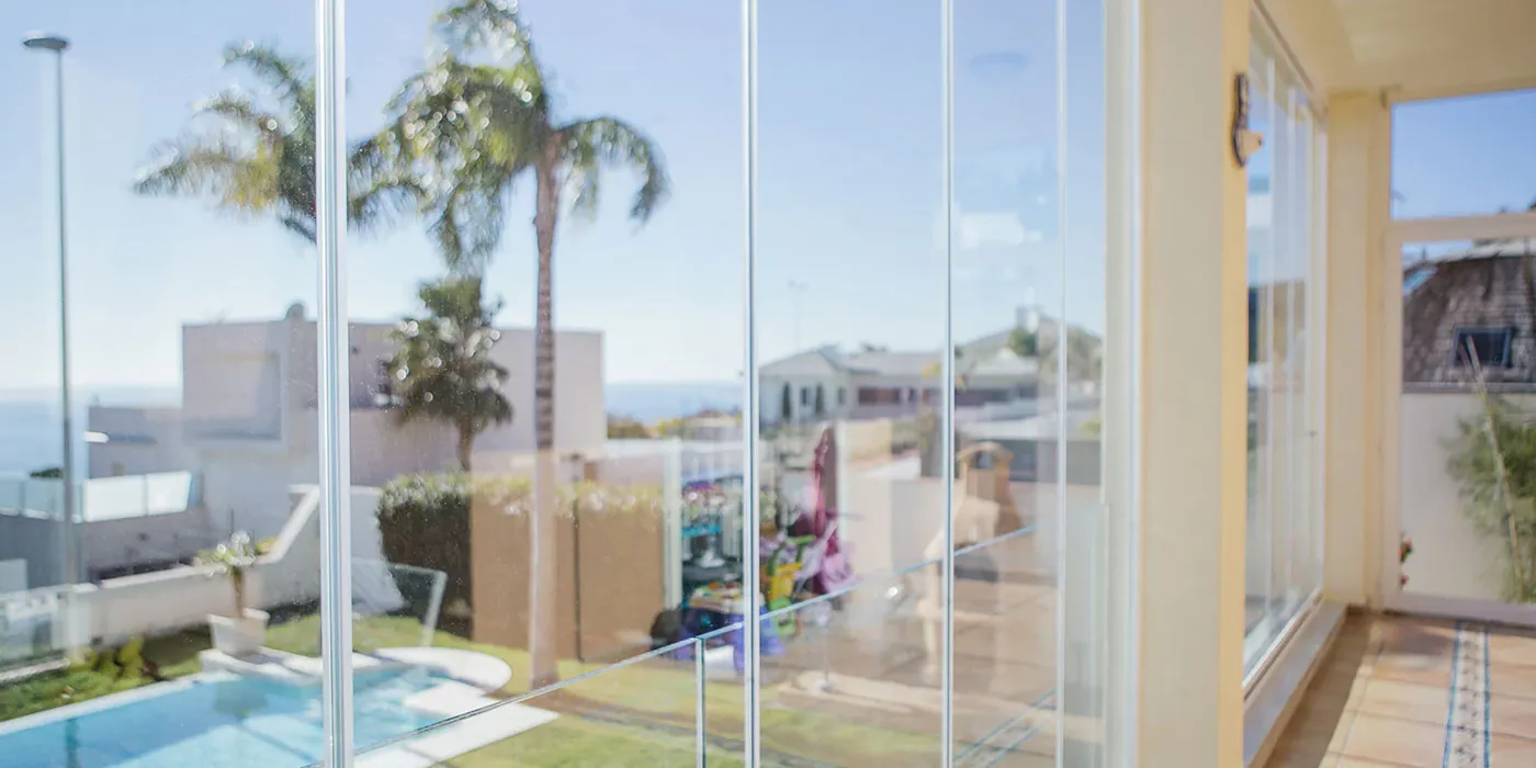 Cortina de cristal para terraza con apertura deslizante. Ejemplo de instalación para mantener luz y vistas